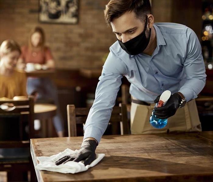 disinfecting table at a business
